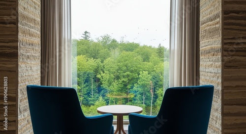 Armchairs facing window with forest view