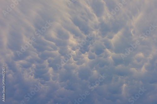 Mammatus cloud formation illuminated by soft evening light, creating a textured and dramatic sky pattern.