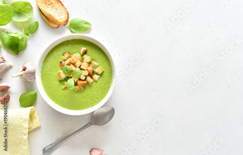 Spinach soup with croutons in white bowl