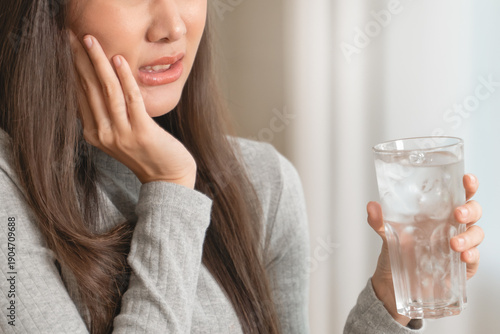 Foto Face expression suffering from sensitive teeth, Asian young woman touching cheek