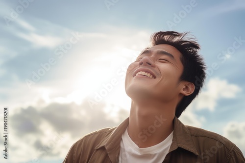Young man smiling and feeling the sun's warmth on his face