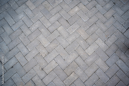 Quadro su tela Top view of grey rectangular paving blocks in a classic herringbone pattern