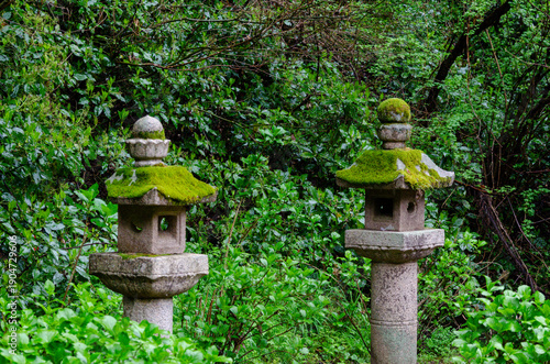 Foto Stone lanterns with moss in tranquil Japanese garden setting