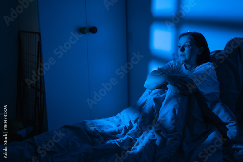 Quadro su tela Middle-aged woman sitting in bed at night suffering from insomnia and stress, tired female feeling exhausted and overworked unable to sleep in dark bedroom