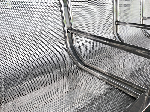 perforated stainless steel waiting bench in public transit station close up