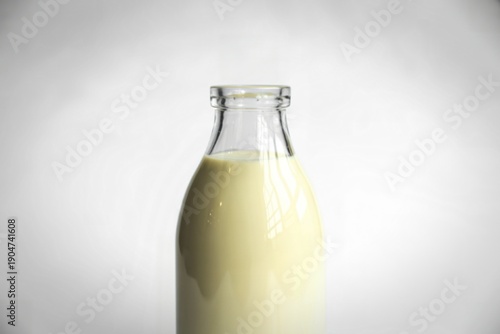A clean product photograph of a milk bottle filled with milk