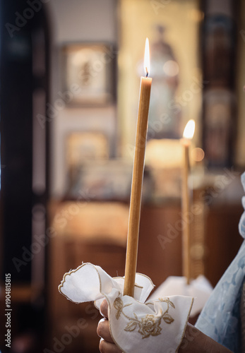 Lit candles in hands of spouses at Wedding Sacrament in Orthodox Church