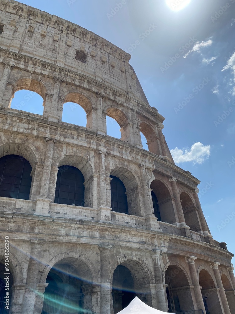 Obraz premium The Colosseum in Rome, iconic ancient Roman amphitheater, dramatic perspective, warm sunset lighting, detailed stone textures, monumental architecture, historic atmosphere, high-resolution editorial t
