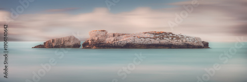 Dreamy seascape rocky islet and blurred water