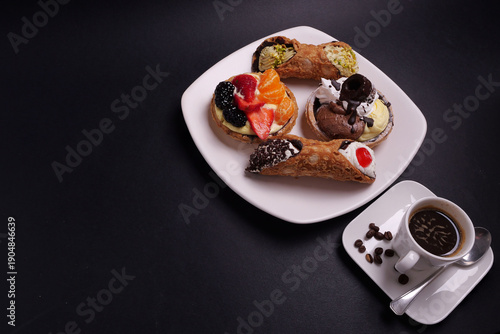 Piatto con paste  e tazzina di caffè per  colazione su sfondo nero, spazio per testo 