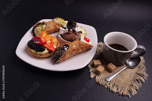 Piatto con paste per colazione e tazza con caffè