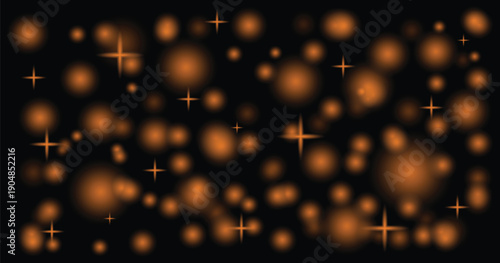 Abstract blurred orange bokeh lights against a dark black background create a soft glow