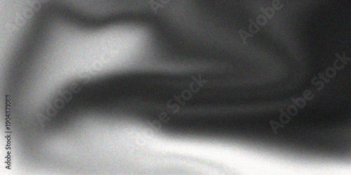 Luxurious black satin fabric with smooth silky waves creates a soft shiny texture and elegant material backdrop for fashion design