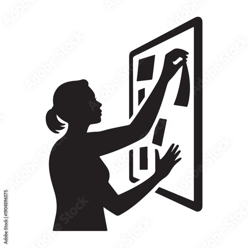 Silhouette of a woman arranging items on a board planning