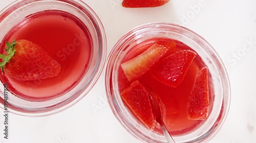 Strawberry gelatin dessert in glass bowls, close-up on a white table. High quality 4k footage