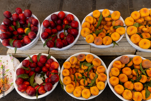 Top view, natural pattern of round bowls containing fresh, colorful apricots and peaches, Chorsu Bazaar, Tashkent, Uzbekistan