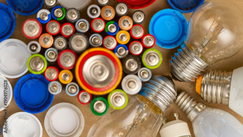 Quadro su tela A bunch of batteries and light bulbs are scattered on a table
