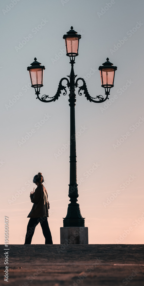 Obraz premium silhouette of a man with earphones next to a vintage lantern