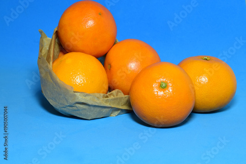 Fotografija Natural oranges on a blue background. Copy space.
