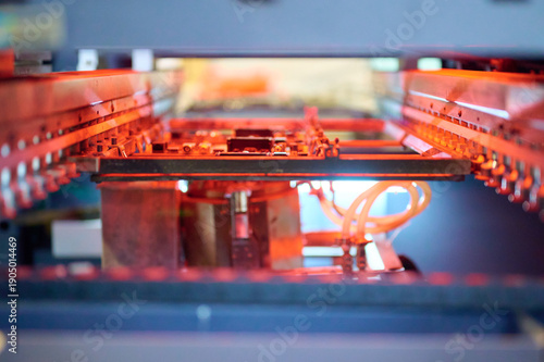 Surface mounting process during reflow soldering with visible heating elements and printed circuit boards in operation