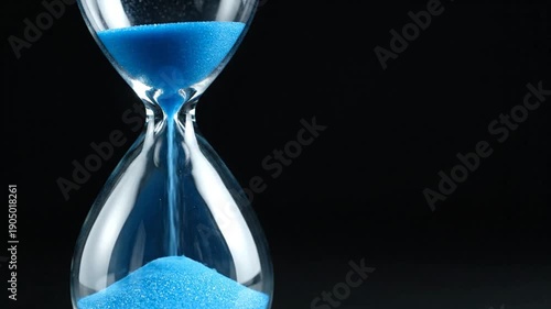 Blue Sand Hourglass on Black Background, time management concept