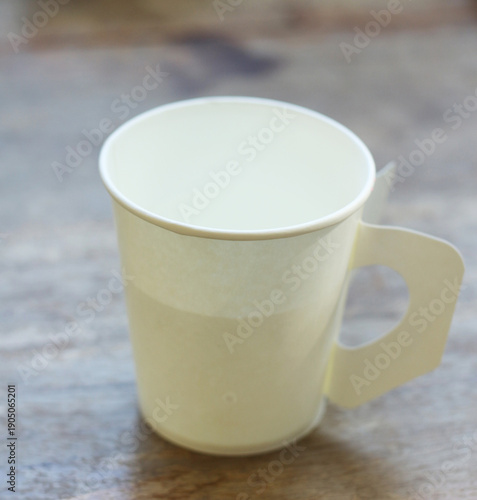 Wallpaper Mural A paper cup is placed on the wooden table. Torontodigital.ca