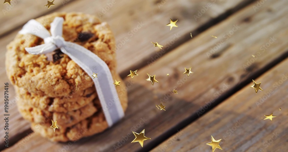 Fototapeta premium Displaying oatmeal cookie stack tied with pale ribbon on worn wooden plank, gold stars, copy space