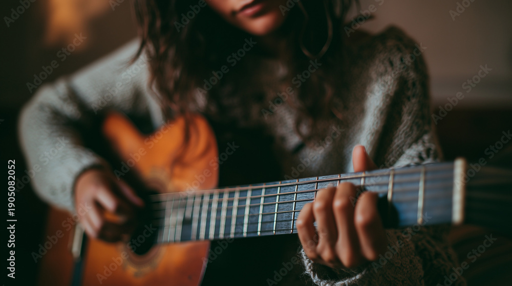 Fototapeta premium young woman playing acoustic guitar close up, fingers on guitar strings musical hobby, soulful musician practicing at home