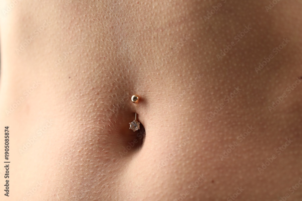 Fototapeta premium Woman with belly button piercing, closeup view