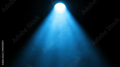 Blue spotlight beam illuminates dark space with visible smoke particles.