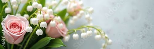 Soft pink rose and white lily of valley flowers arranged in elegant bouquet. Green stems and leaves create natural beauty for spring celebration or wedding decor.