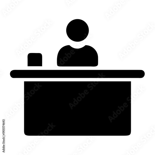 Silhouette of a receptionist working at a front desk with a computer monitor.