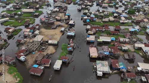 A high-angle drone shot providing a detailed look at the traditional stilt architecture and the intricate network of water paths in Ganvie, West Africa