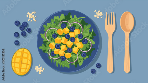 Healthy salad bowl viewed from above with leafy greens, blueberries, mango cubes, and sustainable wooden utensils.