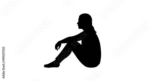 Silhouette of a young woman sitting on the ground looking away thoughtfully.