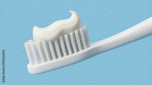 Close-up of a white toothbrush with toothpaste on light blue background. Ideal for dental hygiene, oral care, and health concepts. Clean, minimalistic design for healthcare and beauty projects.