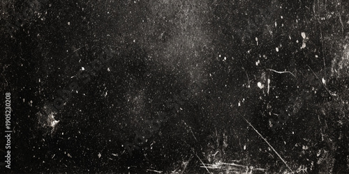 A heavily textured black background with numerous white scratches specks and subtle linear markings is prominently displayed
