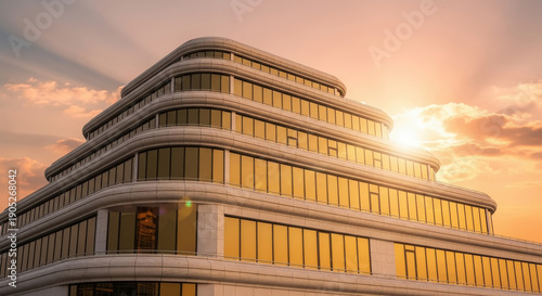 Modern corporate building with curved glass facade illuminated by golden sunset, viewed from low angle, showcasing contemporary architecture and urban landscape