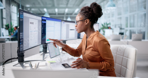 Фотография Young African-American Woman Using Computer To Handle Taxes