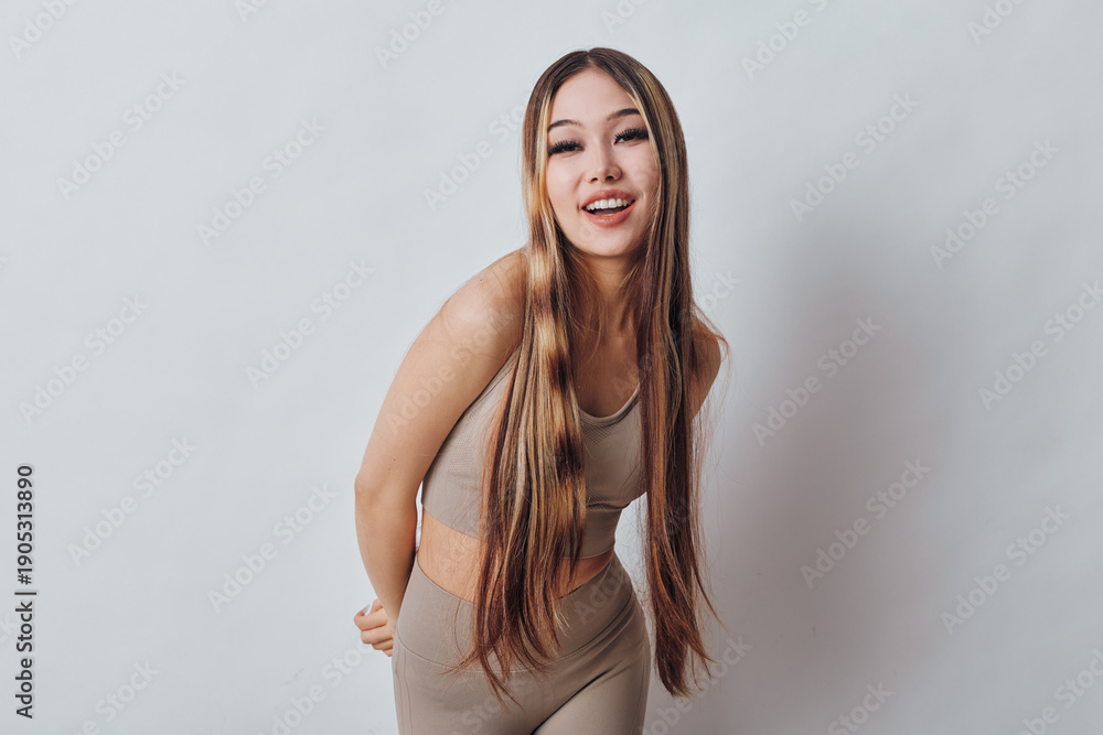 Fototapeta premium Young woman with long braids smiling and posing in casual outfit against plain background. Beauty, hairstyle, fashion and happiness in studio for portrait photography and lifestyle.