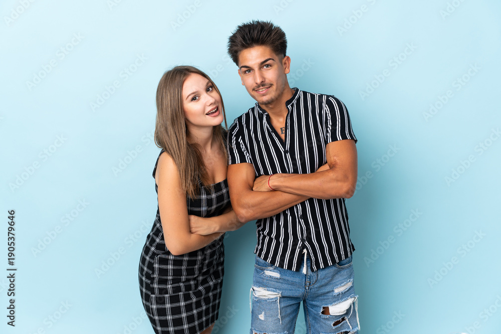 Naklejka premium Teenager caucasian couple isolated on blue background keeping the arms crossed while smiling