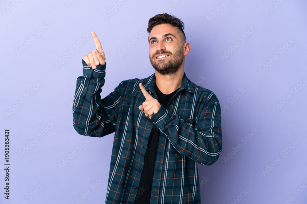 Naklejka premium Caucasian man isolated on purple background pointing with the index finger a great idea