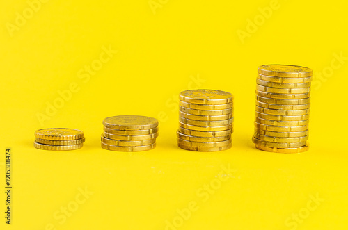 Wallpaper Mural Stacks of gold coins increasing in height against a vibrant yellow background Torontodigital.ca