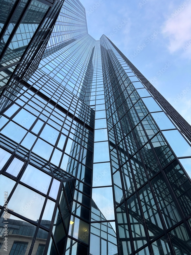 Obraz premium Glass skyscraper with reflections and modern architecture, symbolizing innovation and growth.