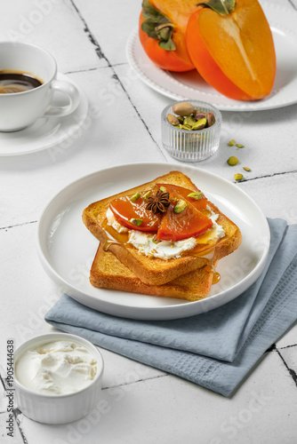 Crispy toasted toast with cottage cheese, caramelized persimmons and pistachio slices drizzled with honey