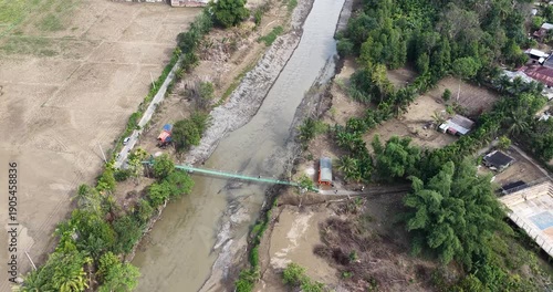 Aerial view of a river with a bridge and surrounding landscape.