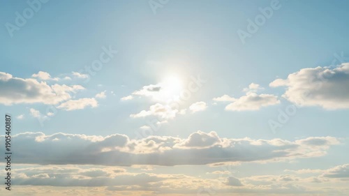 Blue sky with fluffy clouds and bright sun illuminating the scene  