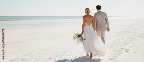 Wallpaper Mural Newlywed couple walks along pristine shoreline in elegant wedding attire holding bridal bouquet. Torontodigital.ca