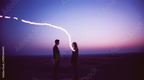 Silhouettes of two people standing apart but connected by a single, glowing thread of light, minimalist landscape at sunset