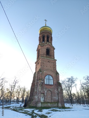 Old pre-revolution Orthodox chapel with golden dome and cross in winter, vertical photo